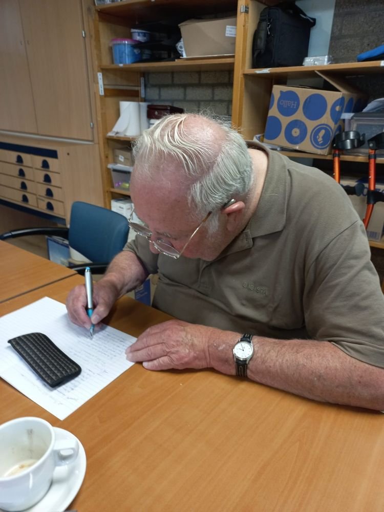 Een man zit geconcentreerd op een wit blad te werken